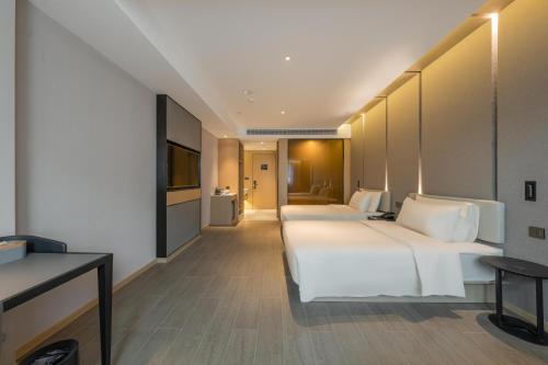 a hotel room with two beds and a television at Atour Hotel Quzhou Nankong in Quzhou