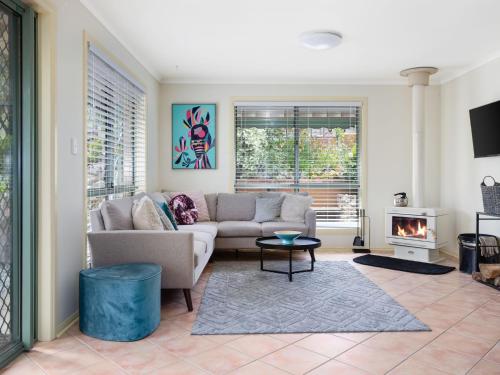 a living room with a couch and a fire place at Dive into Dorset 10 Dorset Court in Carrickalinga