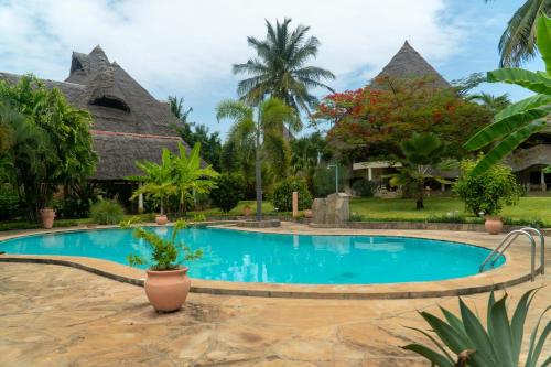 a swimming pool in front of a resort at Amani Paradise - Luxury Villas in Diani Beach