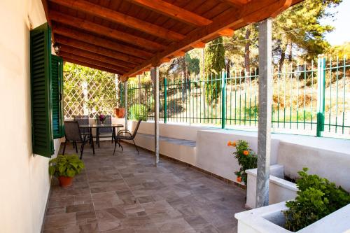 un patio con mesa, sillas y una ventana grande en Spyran Apartment, en Marantochori