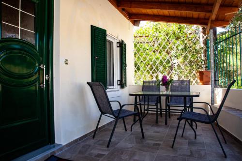 patio con mesa, sillas y puerta verde en Spyran Apartment, en Marantochori