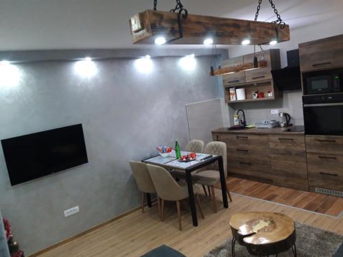 een keuken en eetkamer met een tafel en een televisie bij Iznad oblaka A3 kod Kraljevih čardaka Vikend naselje bb in Kopaonik