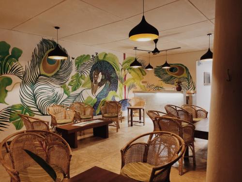 une chambre avec des chaises et un mur orné d'une fresque murale. dans l'établissement Alice in Paradise, à Unawatuna