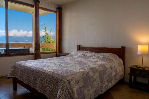 a bedroom with a bed and a window at Hotel Terrazas Del Lago in San Antonio Palopó
