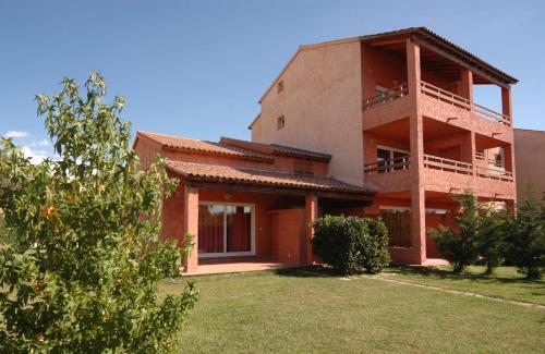 - un grand bâtiment avec une cour devant dans l'établissement Studio 2 people - 150 m from de sea - Ghisonaccia, à Ghisonaccia
