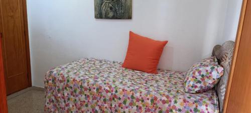 a bedroom with a bed with an orange pillow at Ideal location Very spacious apartment in Maspalomas