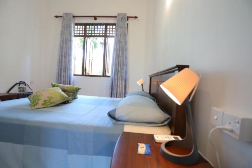 a bedroom with a bed and a window at Villa Sole in Kandy