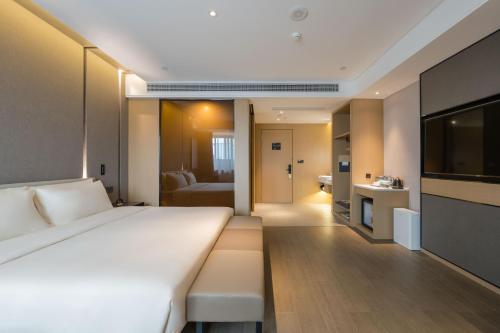 a hotel room with a large bed and a bathroom at Atour Hotel Quzhou Nankong in Quzhou