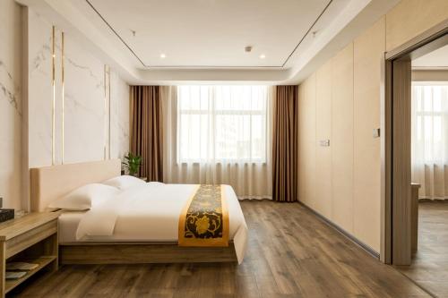 een slaapkamer met een bed en een groot raam bij Suoxing Hotel Longxian Passenger Bus Station in Long