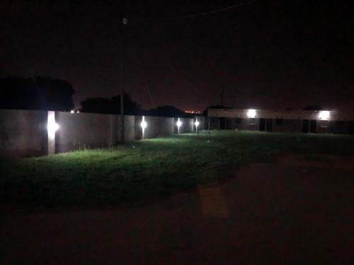 a yard at night with lights on a wall at Mphagahle B&B in Mthenti