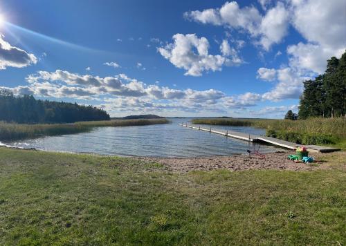 a beach with a dock in the middle of a lake at Relaxing Lake Oasis with Jacuzzi - Amazing view & Private Pier in Stockholm