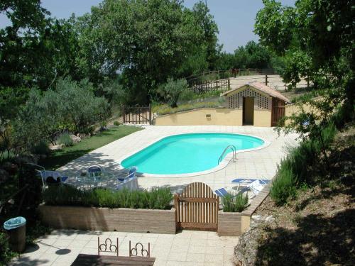a swimming pool in a yard with chairs around it at Malvarina in Capodacqua