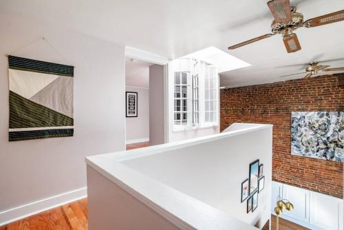 a living room with a ceiling fan and a brick wall at Heart of the Old City- Minutes from Market Square in Knoxville