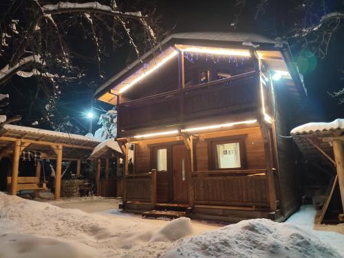 a cabin in the snow with lights on it at Family Plai in Yaremche