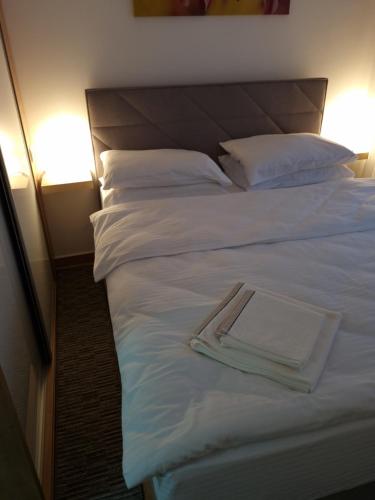 a large white bed with a towel on it at Bankovic Apartman in Vrnjačka Banja