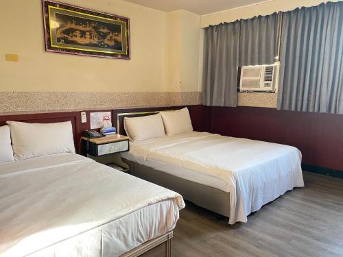 Postel nebo postele na pokoji v ubytování Huang Kai Hotel