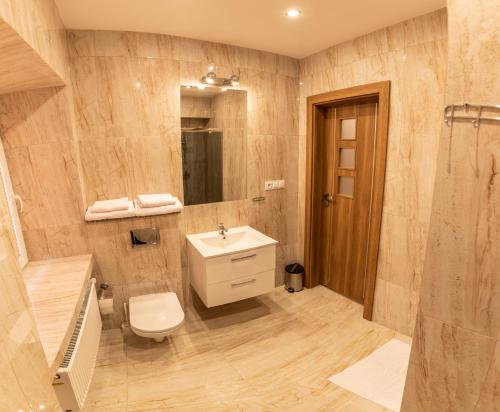 a bathroom with a toilet and a sink and a shower at Apartamenty ZYGFRYD 28C/1 in Bystrzyca Kłodzka