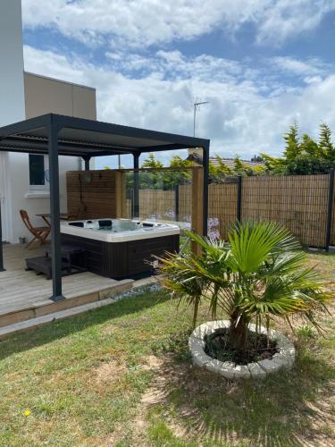 a backyard with a gazebo and a hot tub at "le Skiff", bord de mer et spa, à la VILLA PLEIN VENT in Barneville-Carteret