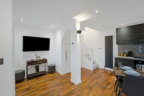 a living room with a television and a dining room at Pitcorthie House in Dunfermline