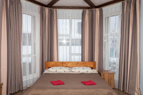 a bedroom with a bed with two red towels on it at Панська Садиба in Mykulychyn