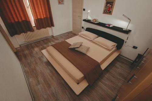 a large bed in a room with a wooden floor at L'Adret in Aosta