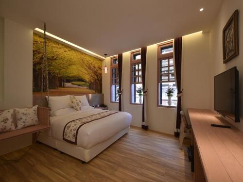 una camera da letto con un letto e una TV a schermo piatto di DG Hotel a Taipei