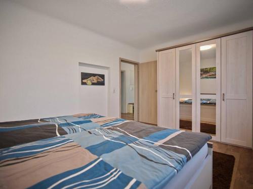 Schlafzimmer mit einem großen Bett mit blauer und weißer Bettwäsche in der Unterkunft Ferienwohnung in der Sportstadt Riesa in Riesa