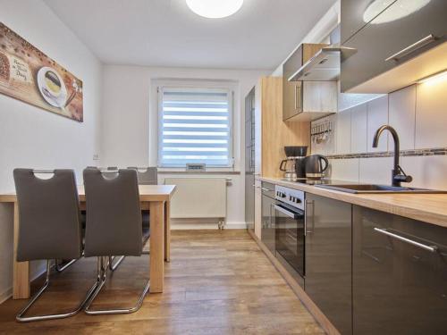 uma cozinha com uma mesa e algumas cadeiras em Ferienwohnung in der Sportstadt Riesa em Riesa