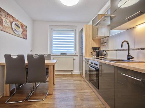 une cuisine avec une table et quelques chaises dans l'établissement Ferienwohnung in der Sportstadt Riesa, à Riesa