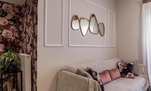 a living room with a couch and two lights on the wall at Zen Luxury Apartments in Xanthi