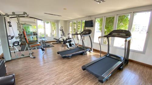 a gym with several treadmills and elliptical machines at Winner Serviced Apartment in Si Maha Phot