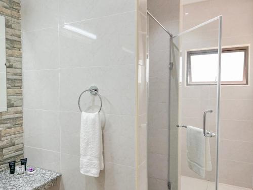 a bathroom with a shower with a glass door at Palm Holiday Apartments in Grand'Anse Praslin