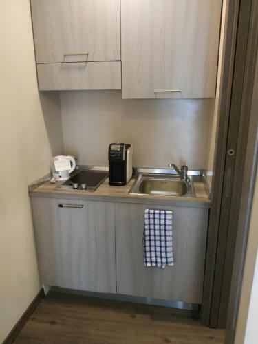 a small kitchen with a sink and a counter top at Casa delle Ginestre Bike in Sanremo