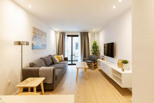 - un salon avec un canapé et une télévision dans l'établissement Apartamentos Deluxe Strada, à Las Palmas de Gran Canaria