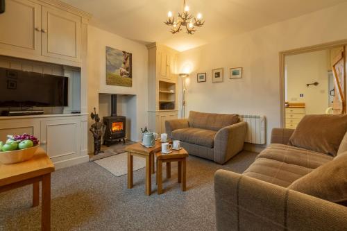a living room with two couches and a fireplace at Knights Rest in Redmire