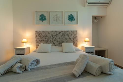 a bedroom with a large white bed with two lamps at Casa Del Corallo in Favignana