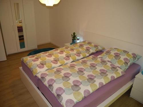 a bedroom with a bed with a flowered blanket on it at Fördeblick-Wassersleben in Harrislee