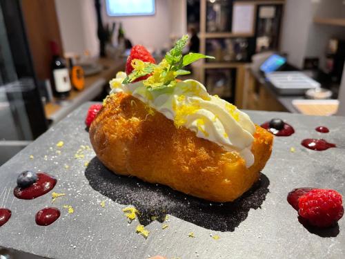 a pastry with whipped cream and a strawberry on a counter at Hotel pas de Cheville in Conthey