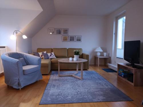 a living room with a couch and a table and a tv at Feddersen's Ferienwohnung in Harrislee