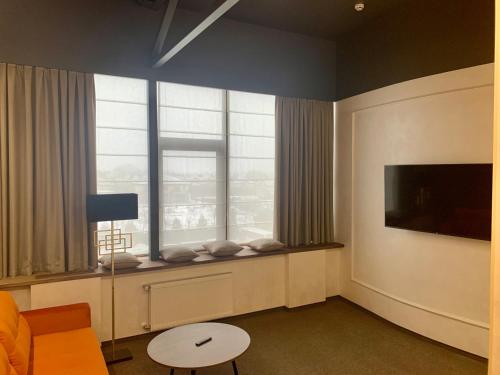 a living room with a window with a couch and a table at WISH Aqua&SPA Resort in Vishenki