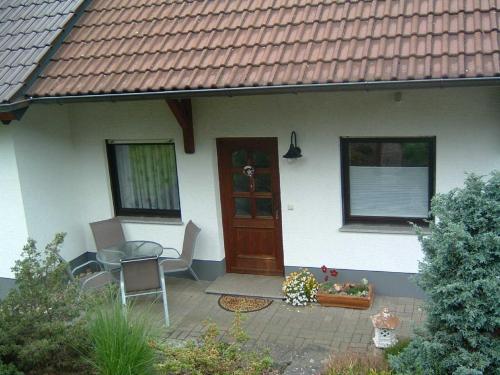 a house with a patio with a table and chairs at Ferienwohnung Hergenröder in Riedenberg
