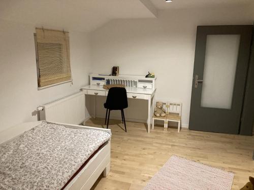 1 dormitorio con cama, escritorio y silla en Maisonettchen en Holzhausen