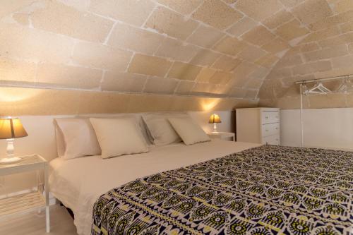 ファヴィニャーナにあるCasa di Ninni Monoの石壁のベッドルーム1室(ベッド1台付)
