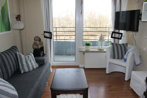 a living room with a couch and a tv at Appartement Tim in Glücksburg