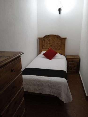 a bedroom with a bed with a red pillow on it at Hotel Valle Bonito, Valle de Bravo in Valle de Bravo