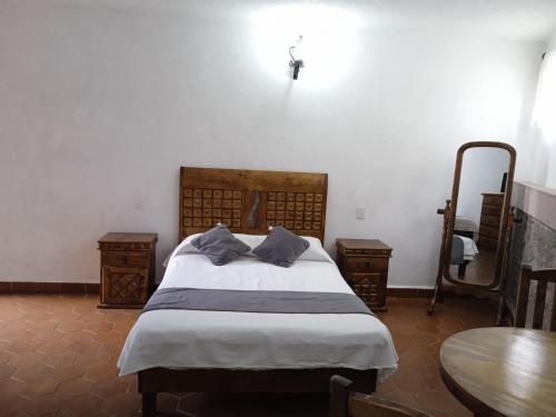 a bedroom with a bed with two pillows and a table at Hotel Valle Bonito, Valle de Bravo in Valle de Bravo