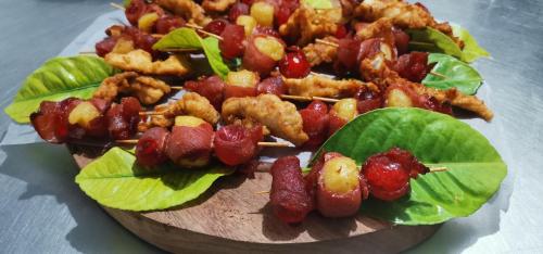 a plate of food on a table with bacon and lettuce at Etotongwe Lodge in Outjo