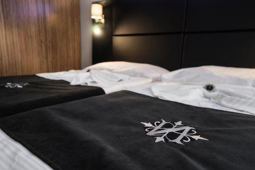 a bed with a black and white blanket on it at Hotel NOIR in Prague