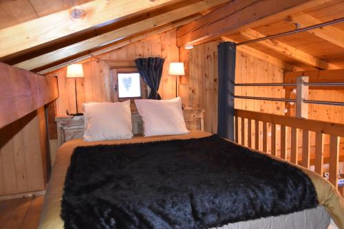 a bedroom with a bed in a wooden cabin at Chalet L'Armoy in La Giettaz