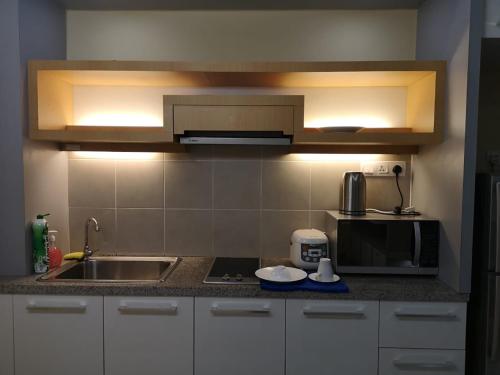 a kitchen with a sink and a microwave at Shaftsbury Residence Cyberjaya with free parking & Netflix in Cyberjaya